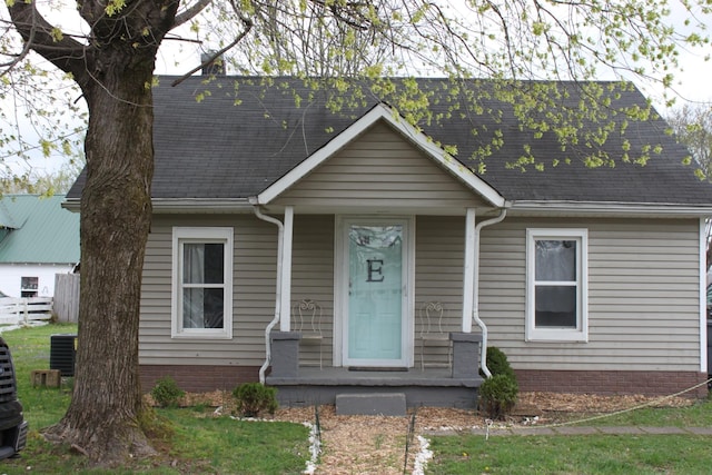cape cod-style house with central AC and roof with shingles