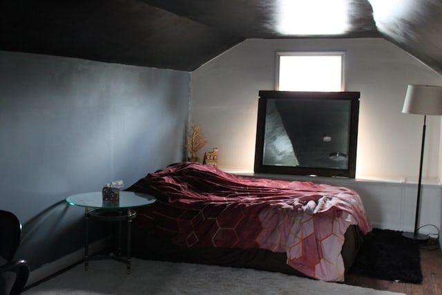 bedroom with lofted ceiling and wood finished floors