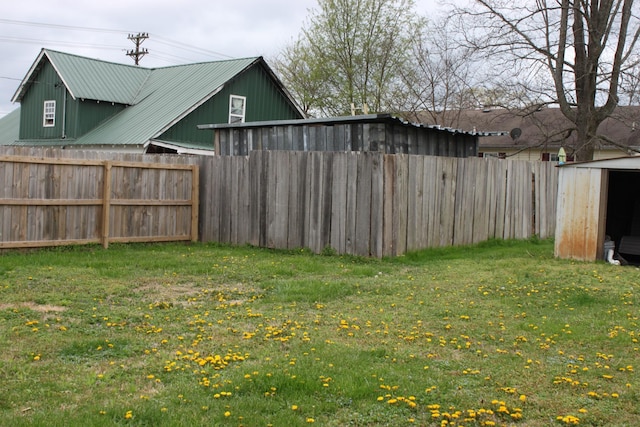 view of yard with an outbuilding, fence, and a shed