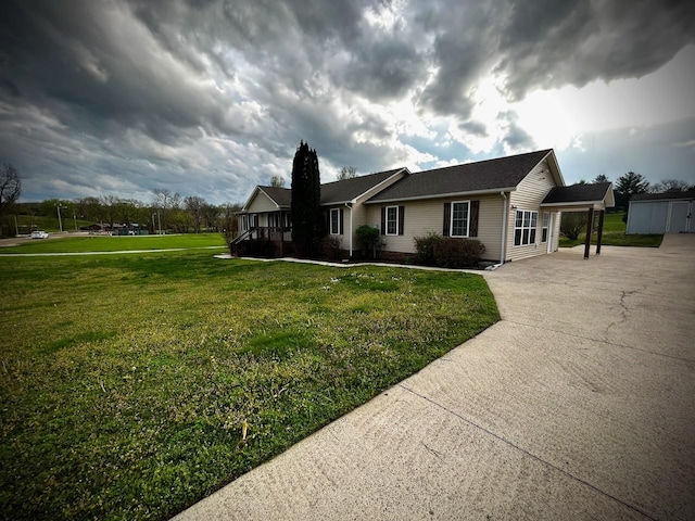 view of front of home with driveway, a front yard, and an outdoor structure