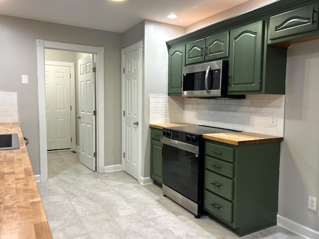 kitchen featuring green cabinets, butcher block counters, stainless steel microwave, electric range, and decorative backsplash
