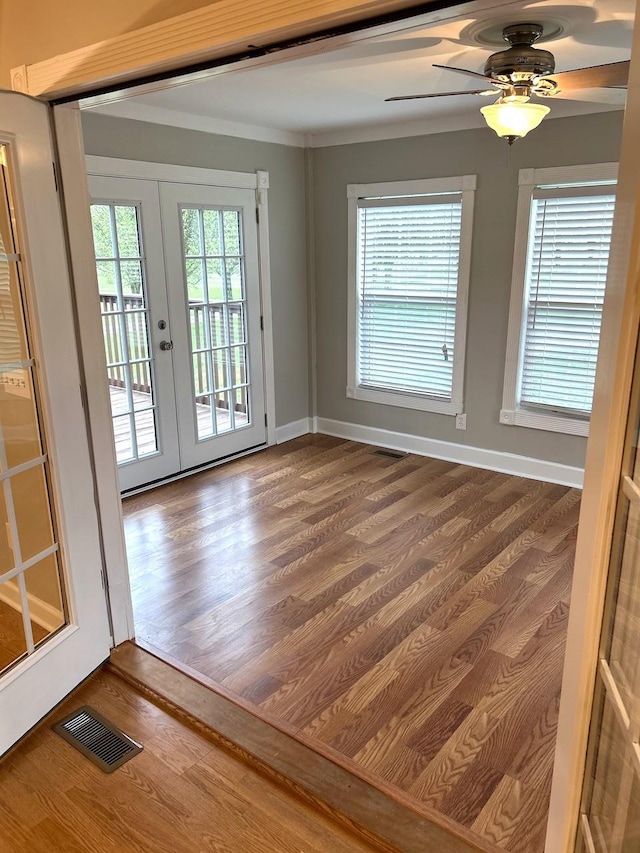 spare room with french doors, dark wood finished floors, baseboards, visible vents, and ceiling fan
