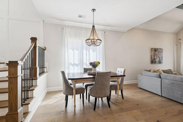 dining space featuring visible vents, a chandelier, light wood finished floors, baseboards, and stairway