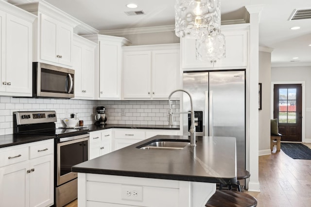 kitchen with visible vents, dark countertops, and appliances with stainless steel finishes