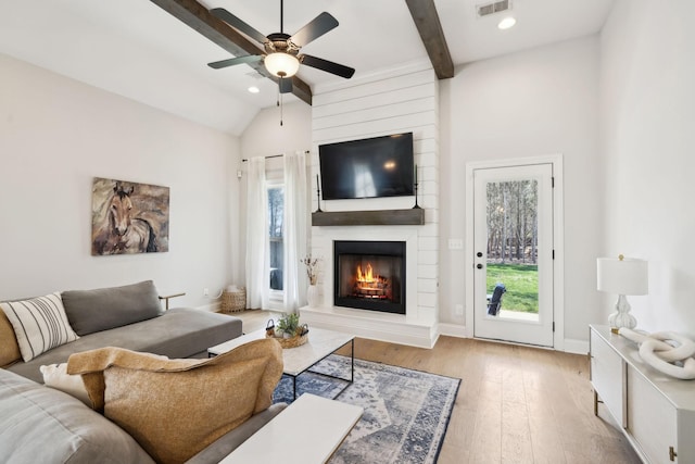 living area featuring a fireplace, wood finished floors, baseboards, ceiling fan, and recessed lighting