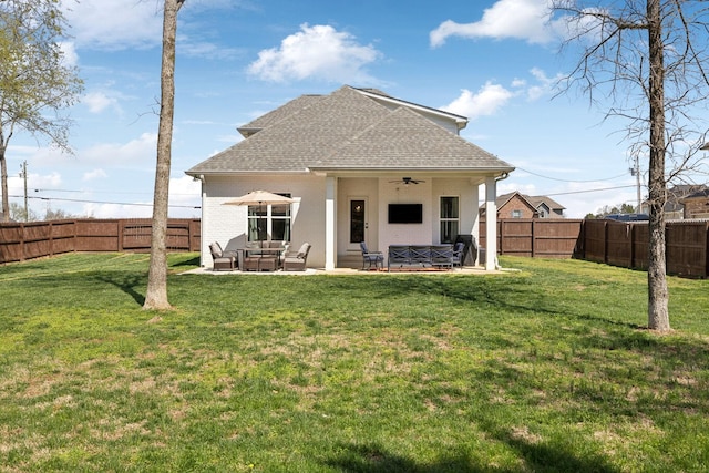 rear view of property featuring a fenced backyard, ceiling fan, an outdoor living space, and a lawn