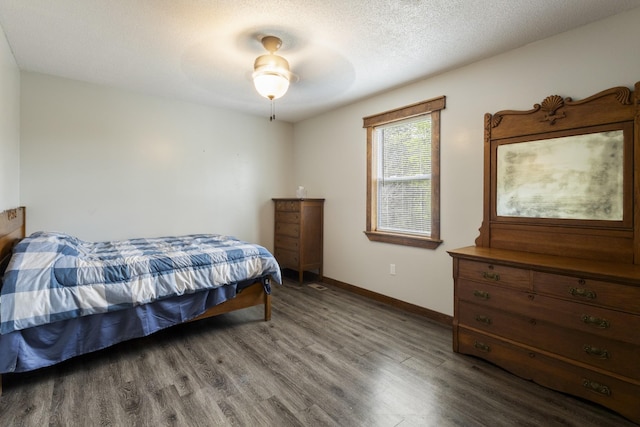 bedroom with baseboards, a textured ceiling, and wood finished floors