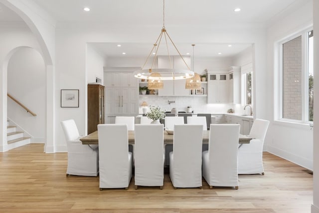 dining room featuring light wood finished floors, baseboards, a notable chandelier, and recessed lighting