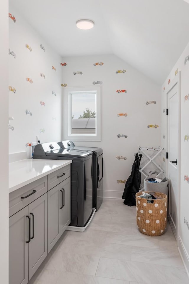 washroom with washing machine and dryer and cabinet space
