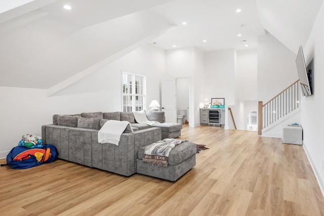 living room featuring recessed lighting, high vaulted ceiling, stairway, and light wood-type flooring