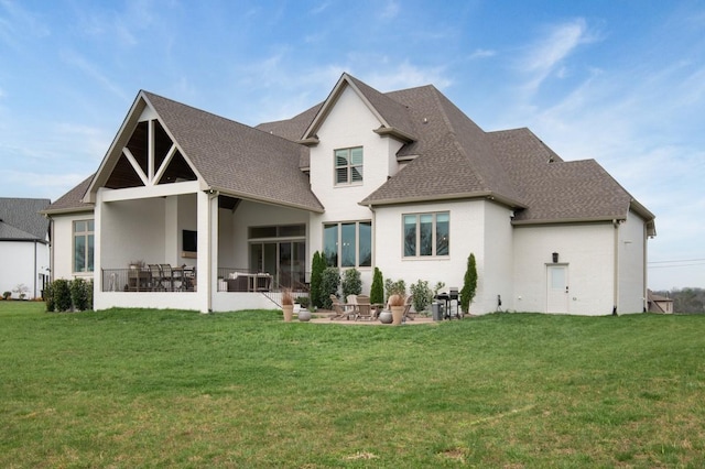 back of house featuring a lawn, a patio area, and roof with shingles