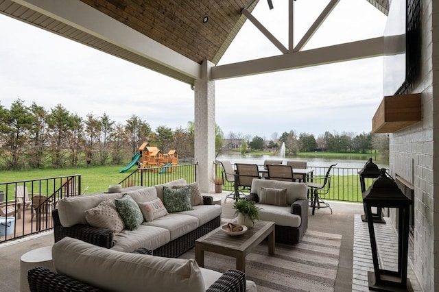 wooden deck featuring a playground, a yard, a water view, and an outdoor living space