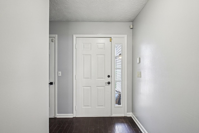 entrance foyer featuring baseboards, a textured ceiling, and dark wood-style flooring