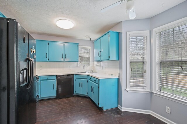 kitchen featuring blue cabinetry, a sink, backsplash, and black appliances