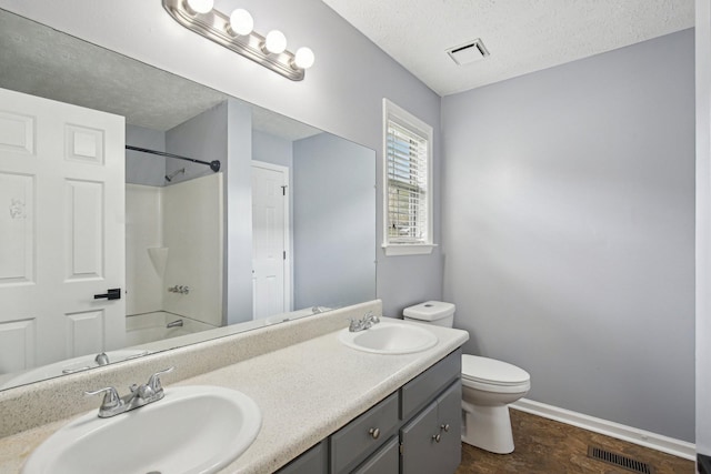 bathroom featuring visible vents, toilet, and a sink
