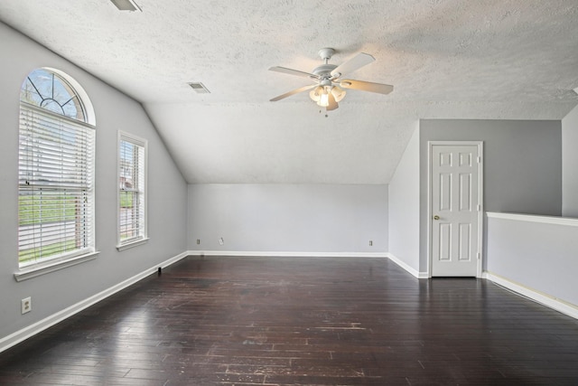 additional living space featuring baseboards, vaulted ceiling, hardwood / wood-style flooring, and a ceiling fan
