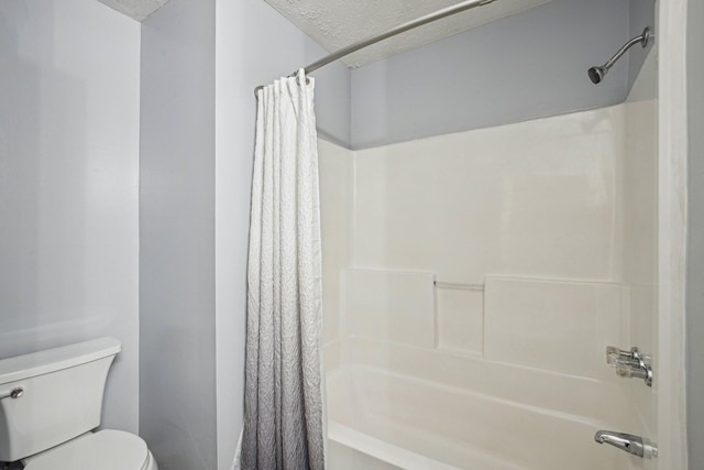 bathroom featuring shower / bath combo with shower curtain, toilet, and a textured ceiling