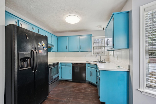 kitchen featuring a sink, tasteful backsplash, blue cabinets, under cabinet range hood, and black appliances