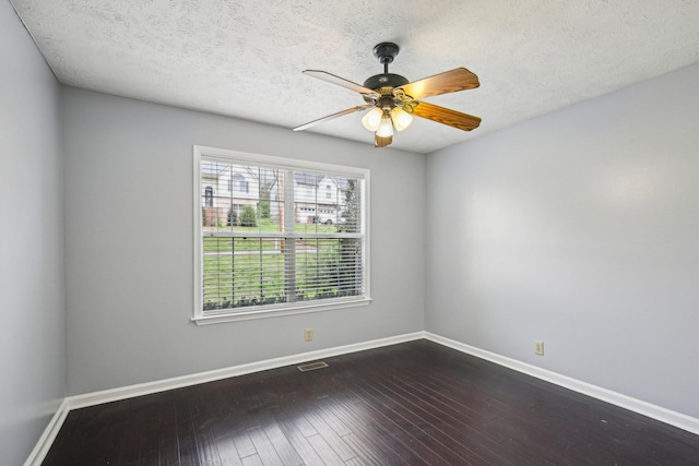 spare room featuring dark wood-style floors, a textured ceiling, baseboards, and a ceiling fan