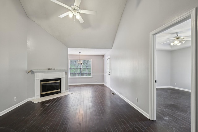 unfurnished living room featuring dark wood-style floors, ceiling fan with notable chandelier, baseboards, and a glass covered fireplace