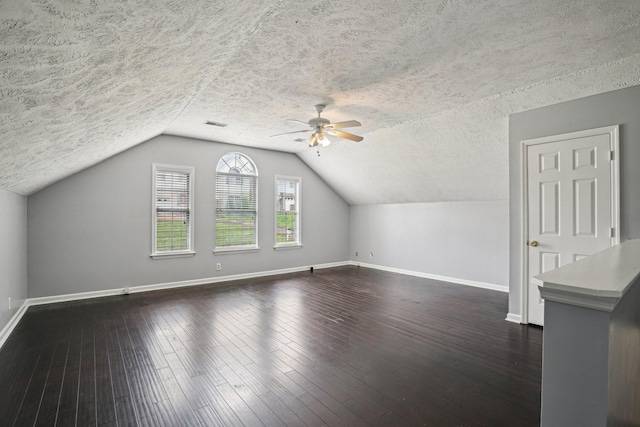 bonus room with baseboards, dark wood-style floors, and ceiling fan
