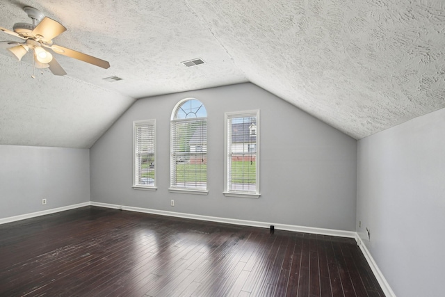 bonus room featuring baseboards, a textured ceiling, vaulted ceiling, and wood-type flooring