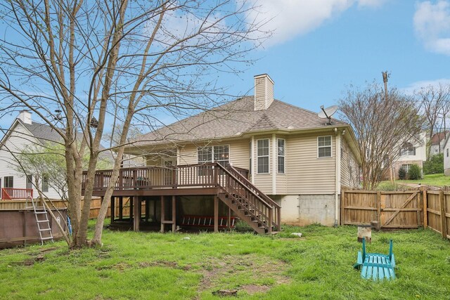 rear view of property featuring a chimney, a fenced backyard, stairway, a deck, and a shingled roof