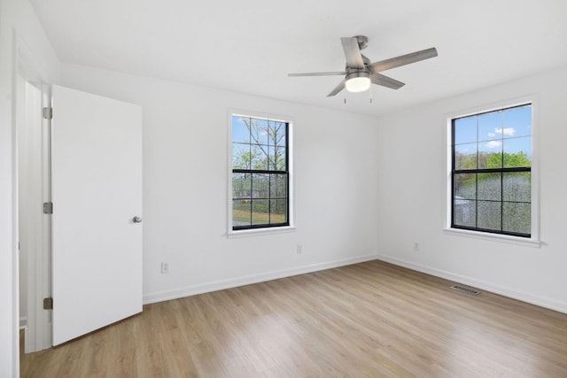 unfurnished room featuring baseboards, a ceiling fan, light wood-style flooring, and a healthy amount of sunlight