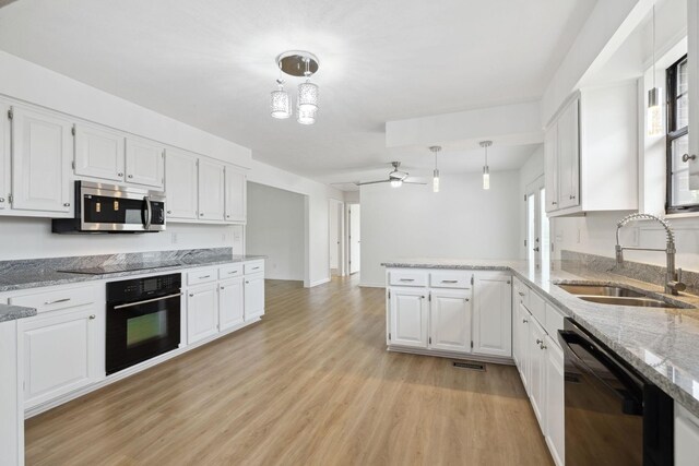 kitchen featuring white cabinets, a sink, and black appliances