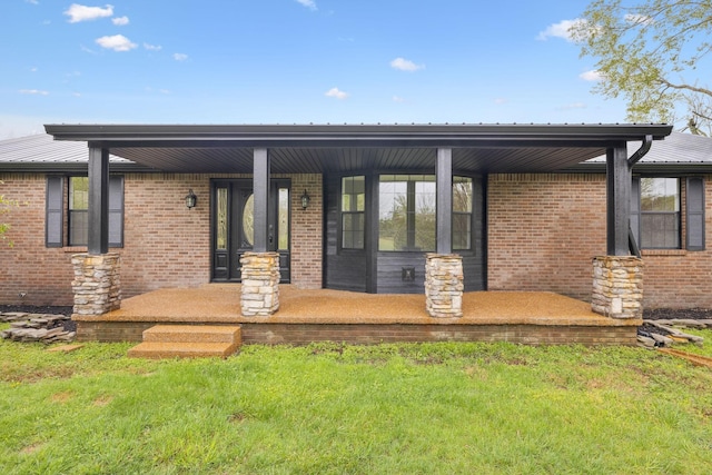 rear view of property featuring covered porch and brick siding