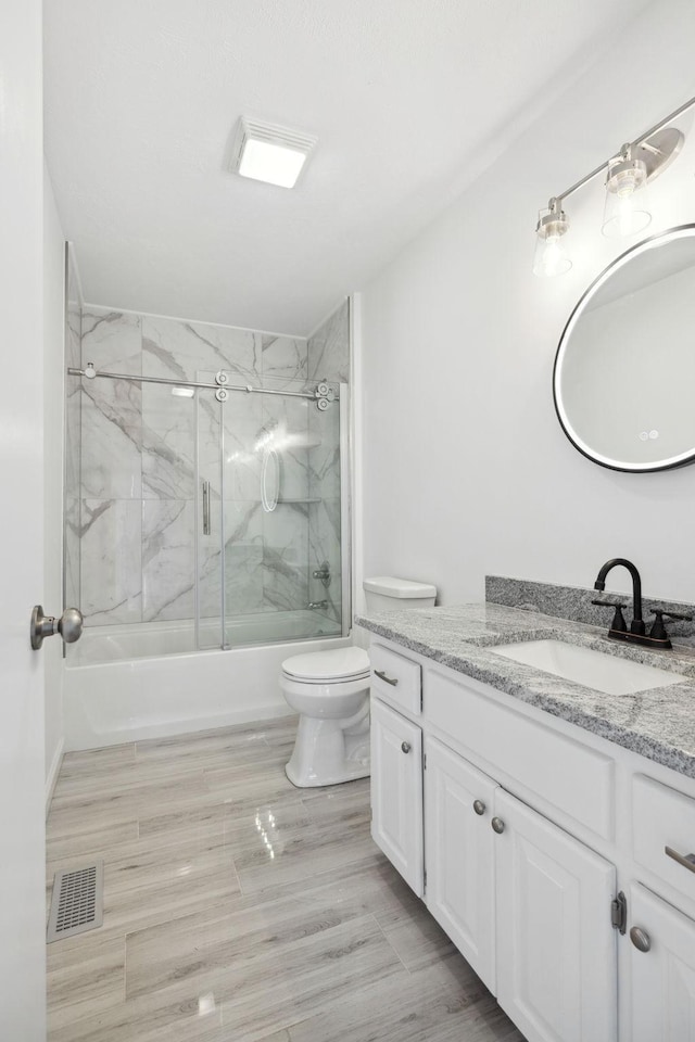 full bathroom with visible vents, toilet, vanity, and enclosed tub / shower combo