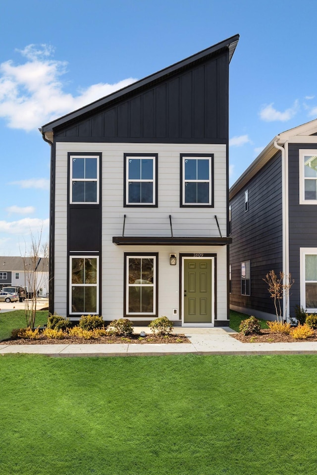 view of front facade with a front lawn and board and batten siding