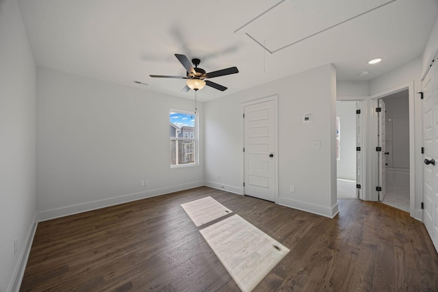 unfurnished bedroom featuring baseboards, visible vents, wood finished floors, and attic access