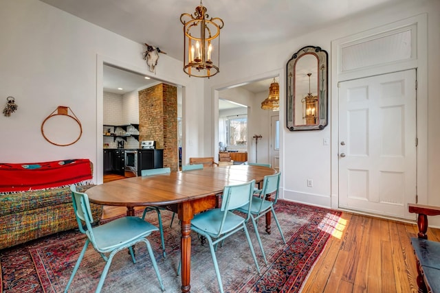 dining space featuring an inviting chandelier, baseboards, and wood-type flooring
