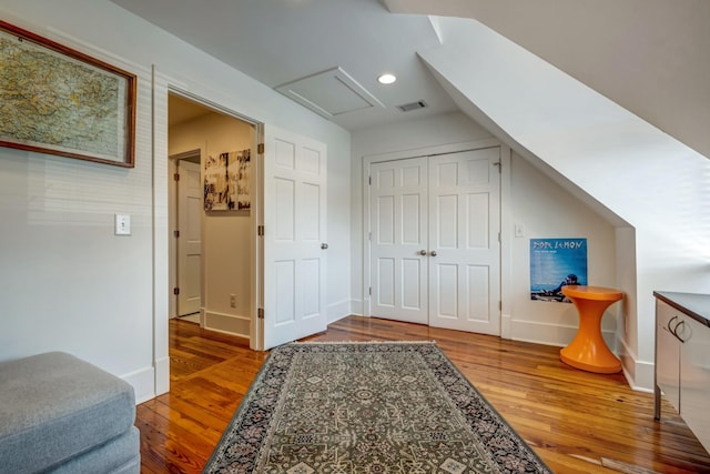 bonus room featuring attic access, baseboards, visible vents, and wood finished floors