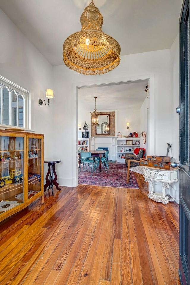 interior space featuring hardwood / wood-style floors, a notable chandelier, and baseboards