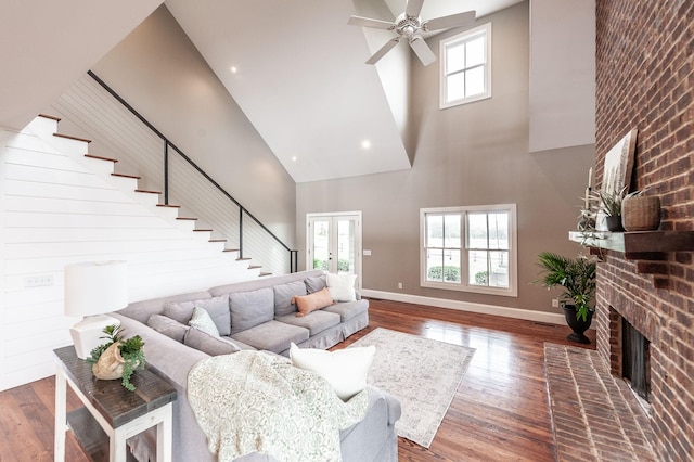 living area featuring a wealth of natural light, ceiling fan, baseboards, and hardwood / wood-style floors