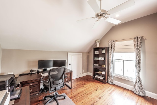 home office with baseboards, ceiling fan, vaulted ceiling, and light wood-style floors