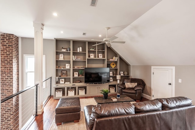 living room featuring decorative columns, light wood finished floors, lofted ceiling, visible vents, and ceiling fan