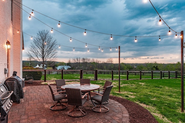 view of patio featuring a rural view, a fenced backyard, outdoor dining space, and area for grilling