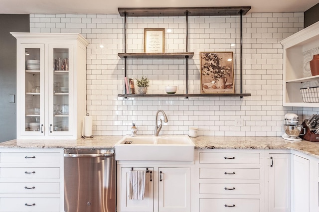 kitchen with white cabinets, a sink, open shelves, and stainless steel dishwasher