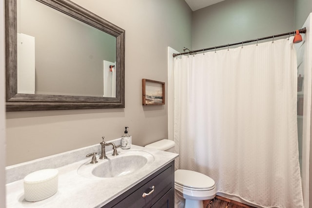 full bath featuring toilet, vanity, and curtained shower