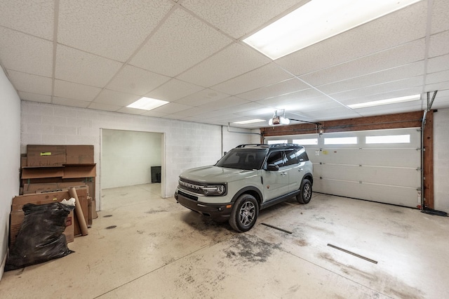 garage with concrete block wall and a garage door opener