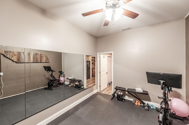 workout room with baseboards, ceiling fan, and visible vents