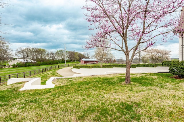 view of home's community with fence and a yard
