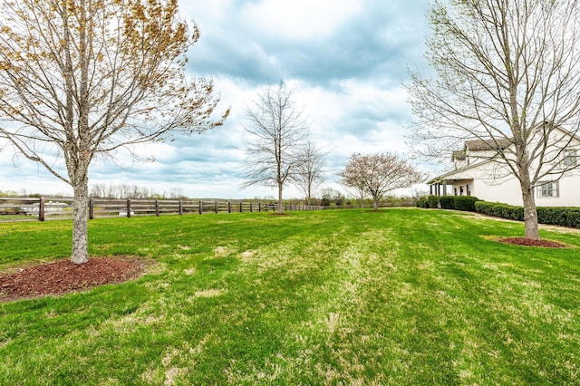 view of yard with fence and a rural view
