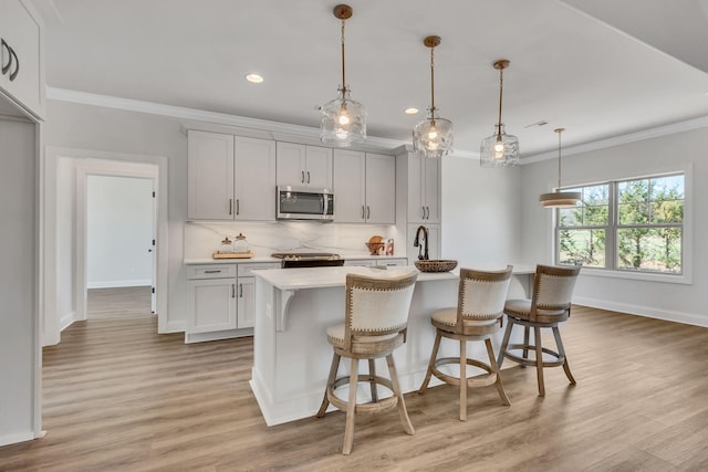 200 Creekside Dr, Lewisburg, TN 37091 - kitchen with light countertops, crown molding, stainless steel appliances, a center island with sink, and backsplash