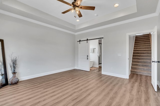 200 Creekside Dr, Lewisburg, TN 37091 - unfurnished bedroom featuring recessed lighting, baseboards, a raised ceiling, light wood-style floors, and a barn door