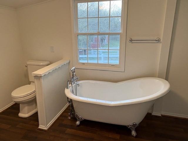 1833 Porterfield Rd, Readyville, TN 37149 - bathroom featuring toilet, a soaking tub, wood finished floors, and baseboards