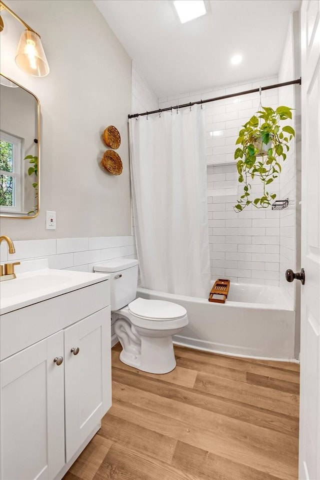 full bathroom featuring vanity, recessed lighting, toilet, shower / bathtub combination with curtain, and wood finished floors